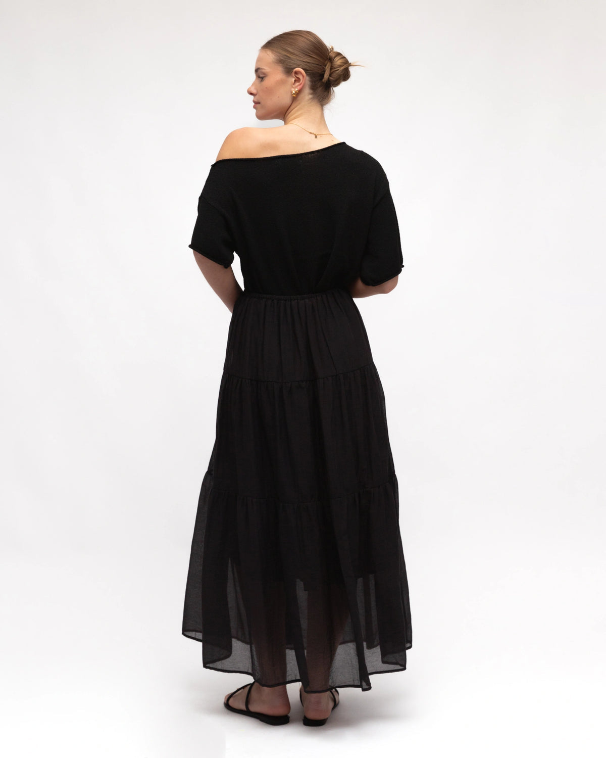 Woman wearing a black off-shoulder dress on a white background