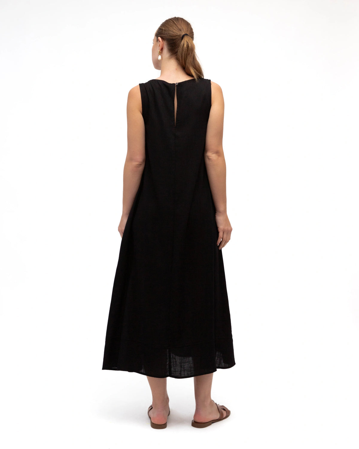 Woman wearing a black sleeveless dress on a white background