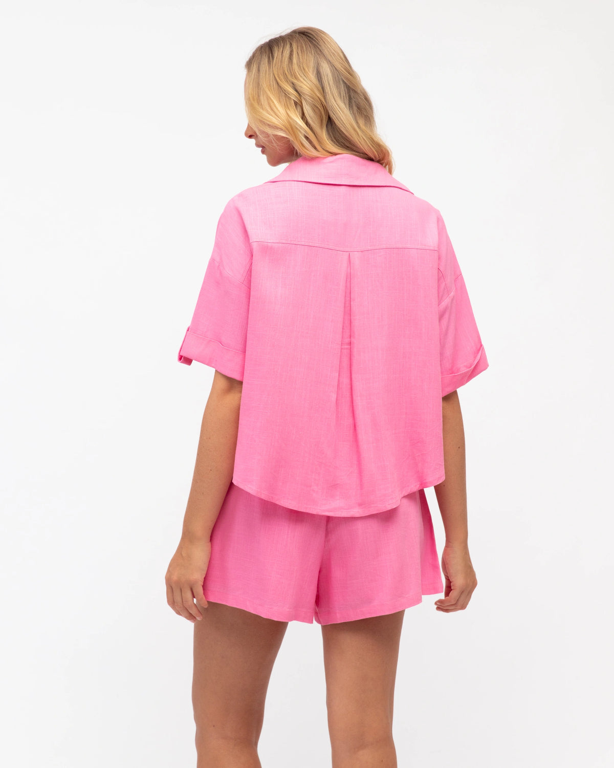 Person wearing a pink outfit on a white background