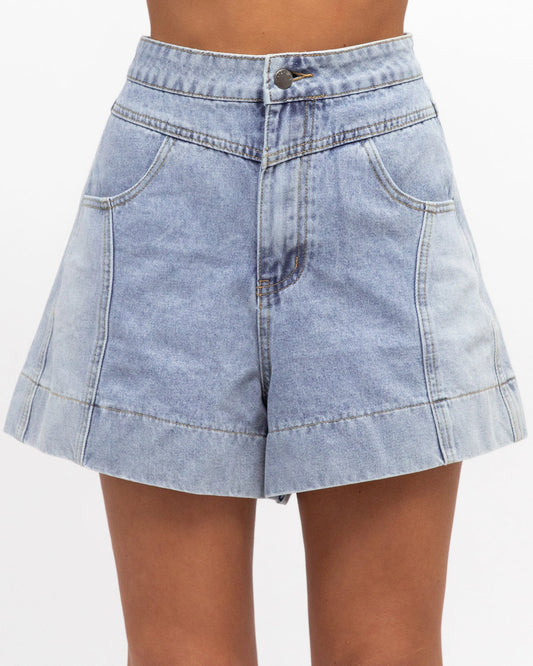 Light blue denim skirt worn by a person on a white background